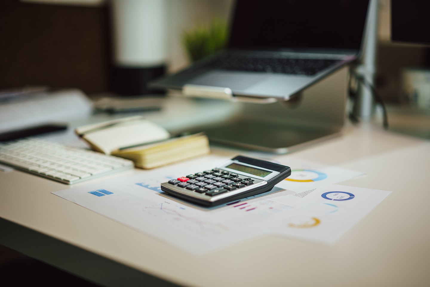 Ofis masasında finansal belgelerin üzerinde hesap makinesi.